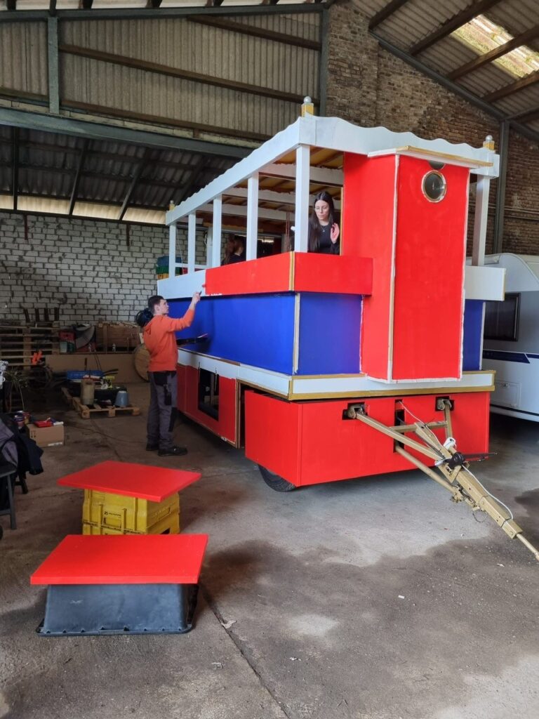 Mitglieder der KG Porzer Stadtgarde e. V. in der Wagenbauhalle beim Neugestalten des Festwagens.